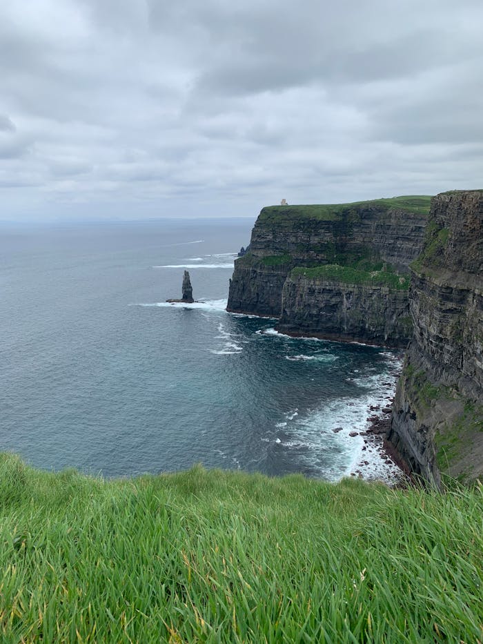 Majestic Cliffs of Moher, Ireland, with lush grass and dramatic ocean views.